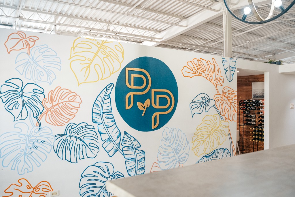 Logo wall of painted leaves, with the cellar beyond