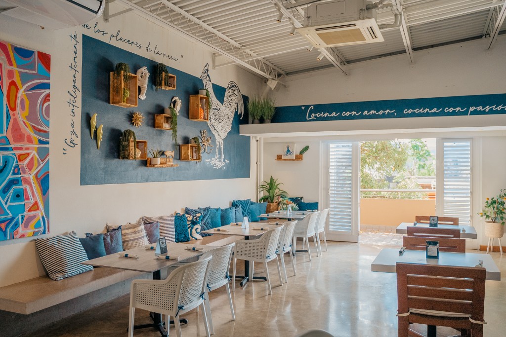 Daytime dining room with the wall phrase and blue bench